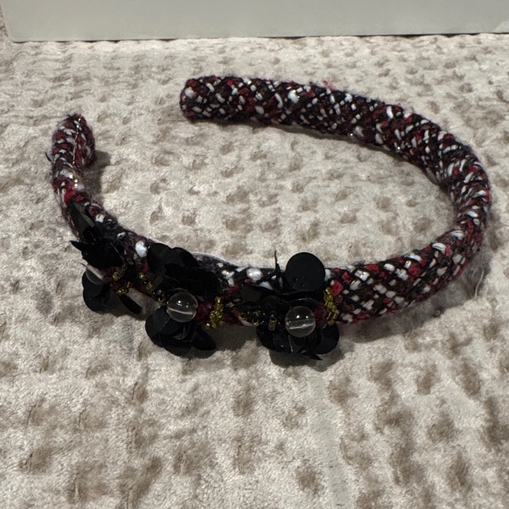 Pili carrera black red and white headband with three black flowers.